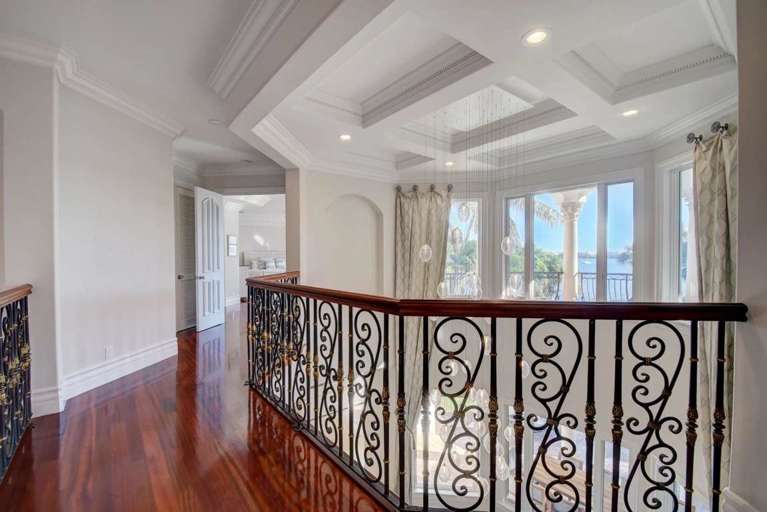 Interior Hallway With Hardwood Floors And Iron Railing Interior Hallway With Hardwood Floors And Iron Railing