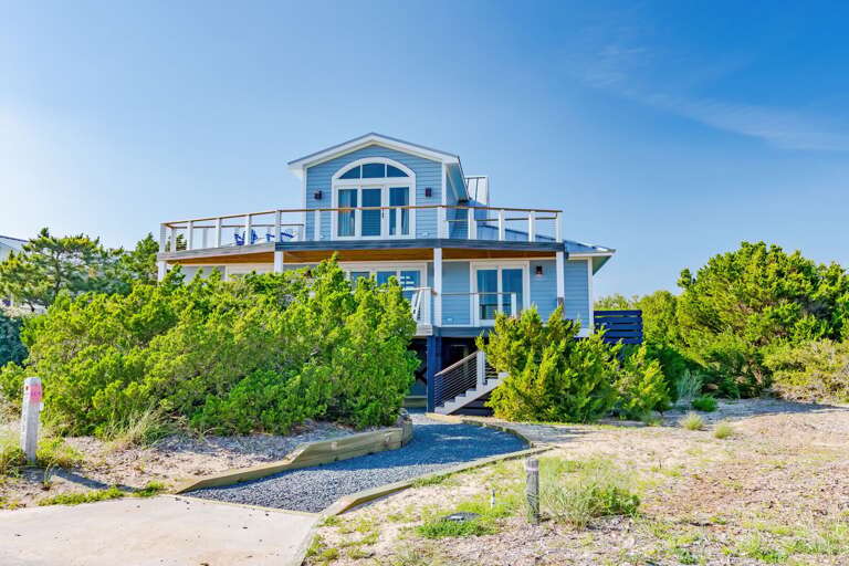 Beachside Building Bordered By Bushes Under Blue Sky