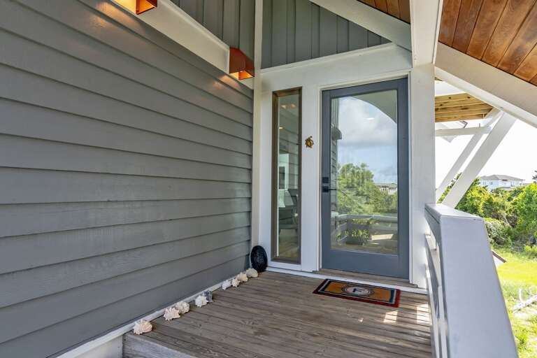 Grey-sided House With Glass Door And Wooden Floor, Lit By Soft Sunlight