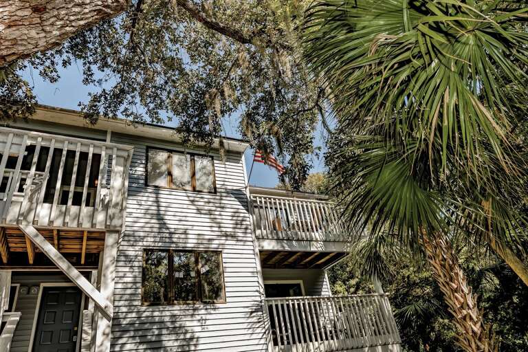 Wooden Vacation Rental Surrounded By Trees And Vegetation