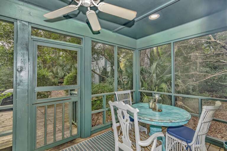 Screened Porch With Ceiling Fan, Glass Doors, And Serene Green Views In Vacation Rental