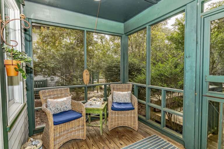 Porch With Wicker Chairs, Wooden Floor, Surrounded By Serene Scenery