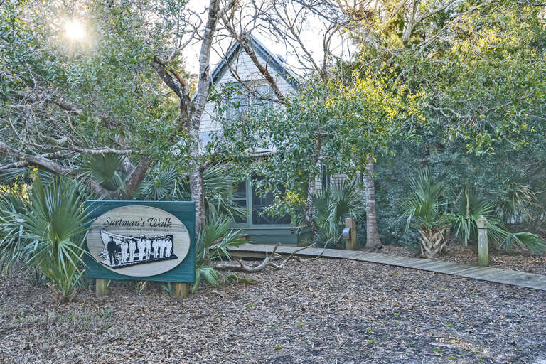 Secluded Structure Surrounded By Greenery, With A Vintage-style Sign In Front