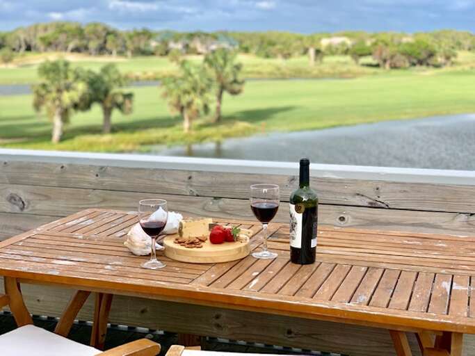 Table Set With Wine And Cheese Overlooking A Lush Lakeside Landscape