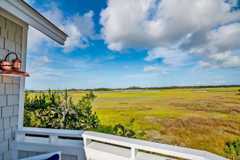 Balcony View Over Breezy, Broad Marsh Under Blue Sky