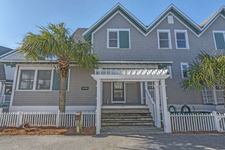 Grey Building With Palm, Porch, And Picket Fence