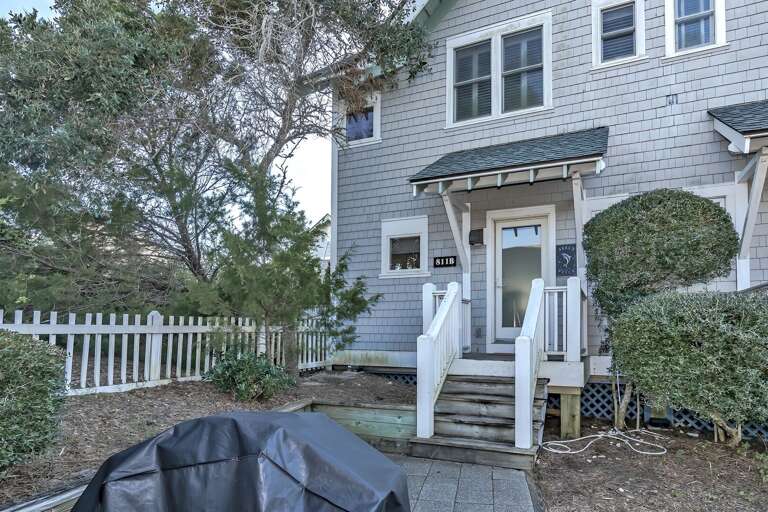 White Wooden House With Fence And Trees
