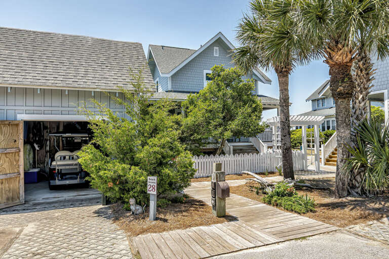 Palm-lined Path Leading To A Spacious Seaside House With Garage