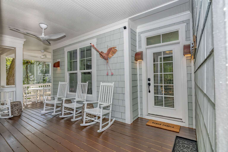 White-washed Wood-walled Porch With White Rocking Chairs And Ceiling Fans