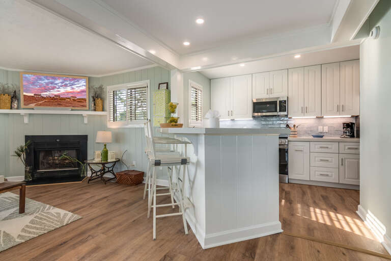 Spacious Living Space With Sleek Kitchen, Serene Sitting Area, And Bright Built-ins