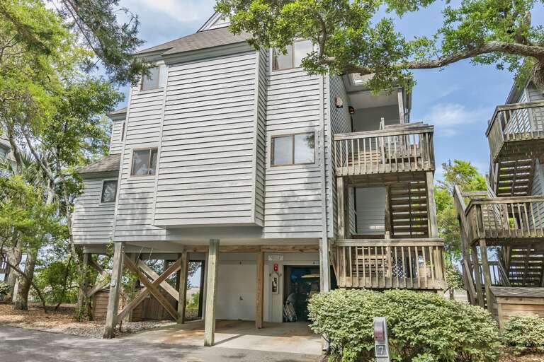 Three-story Structure Surrounded By Trees With Balconies And External Stairs