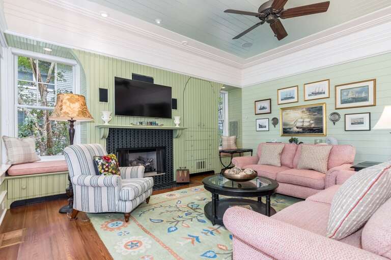 Vacation Rental Living Area With Pastel Palette, Plush Seating, And Paneled Fireplace