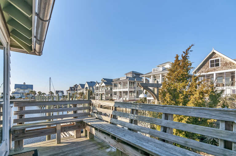 Boardwalk Bridging Beachside Buildings Beneath Blue Sky