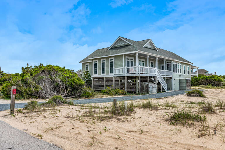 Seaside Structure Surrounded By Sandy Shore And Shrubs