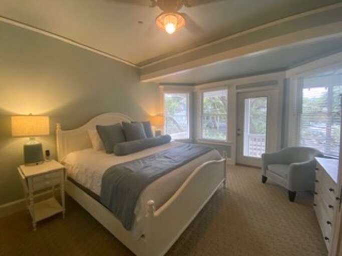 Blue Bed And Beige Walls, White Furniture, Window View