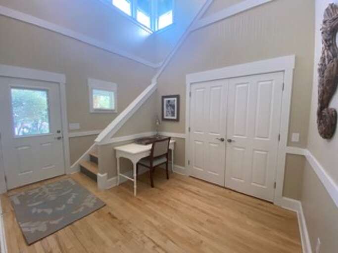 Light-filled Lobby In A Vacation Rental With Wooden Flooring And White Doors