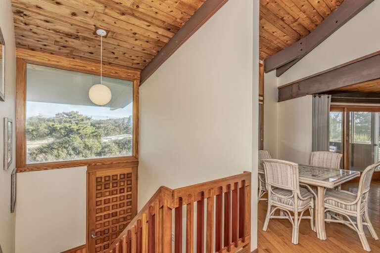 Wooden Indoor Space With Wicker Chairs And Large Window Overlooking Nature