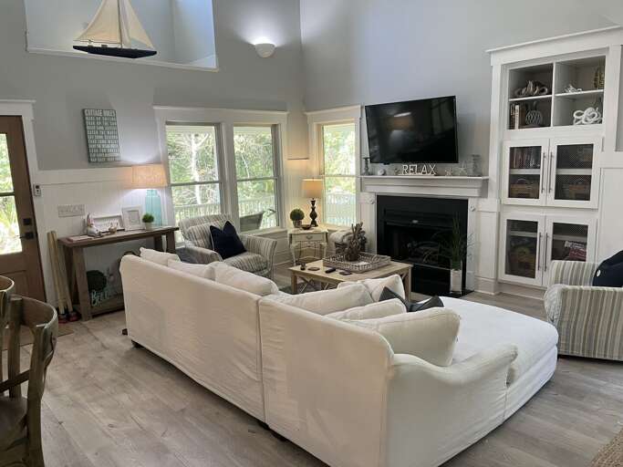 Spacious Living Space With White Sofas, Fireplace, And Built-in Shelves