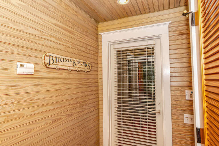 Wood-walled Corridor With Sign And Shuttered Door