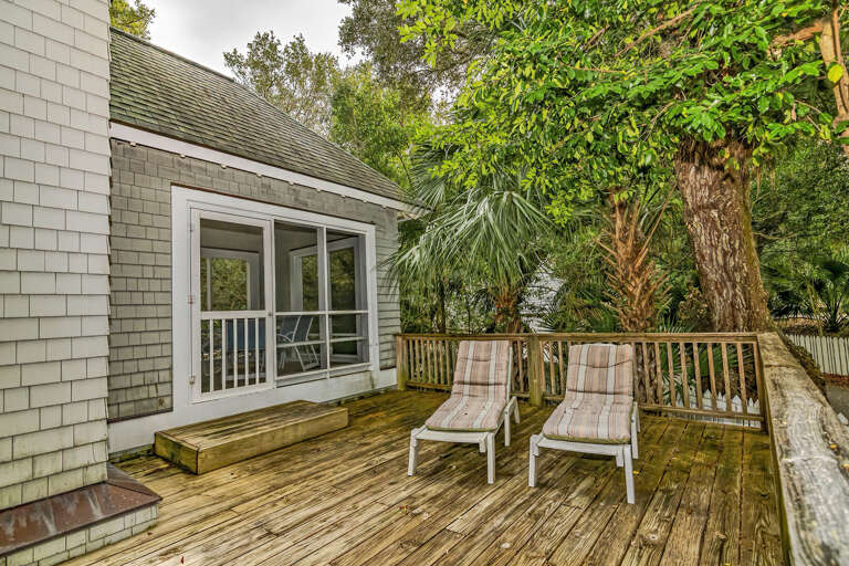 Wooden Deck With Loungers Near Leafy Green Trees