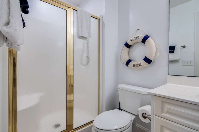 White Bathroom With Golden-trimmed Shower, Sink, Lifebuoy Decor In Vacation Rental