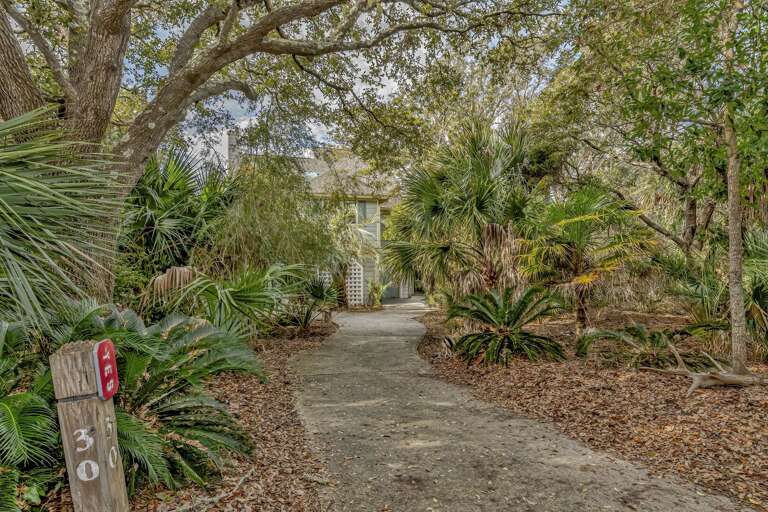 Pathway Leading To A Building Surrounded By Lush Greenery And Trees