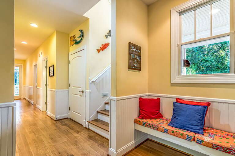 Brightly Lit Indoor Entryway With Bench And Cushions By A Window