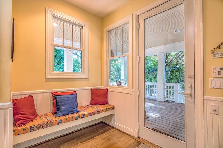 Sunlit Seating Space With Cushioned Bench, Bright Windows, And Balcony Door