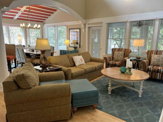 Spacious Sitting Room With Sofas, Wooden Table, And Striped Awning