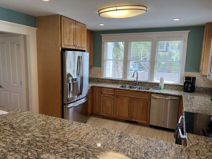 Kitchen With Wooden Cabinets, Granite Countertops, And Stainless Steel Appliances