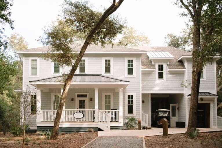 White Wooden House With Porch Under Pine Trees