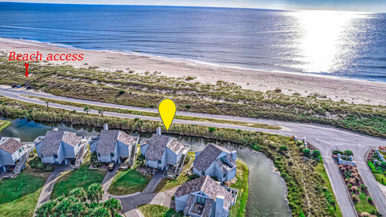 Aerial View Of Seaside Structures Shadowed By Shimmering Sands