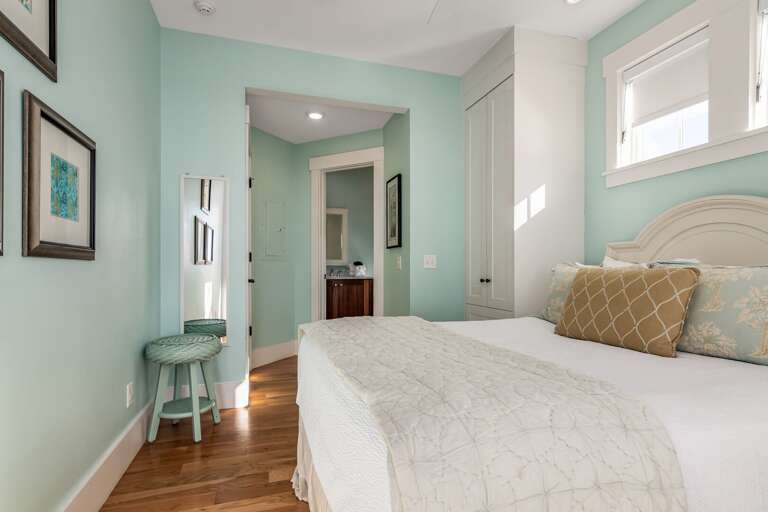 Light Blue Bedroom With White Bed, Framed Art, And Hardwood Floor In Vacation Rental Light Blue Bedroom With White Bed, Framed Art, And Hardwood Floor In Vacation Rental