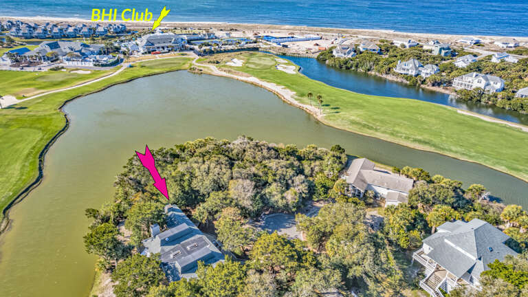 Aerial View Showing Green Golf Course Beside Blue Bay, Pink Arrow Pointing At A Key Location