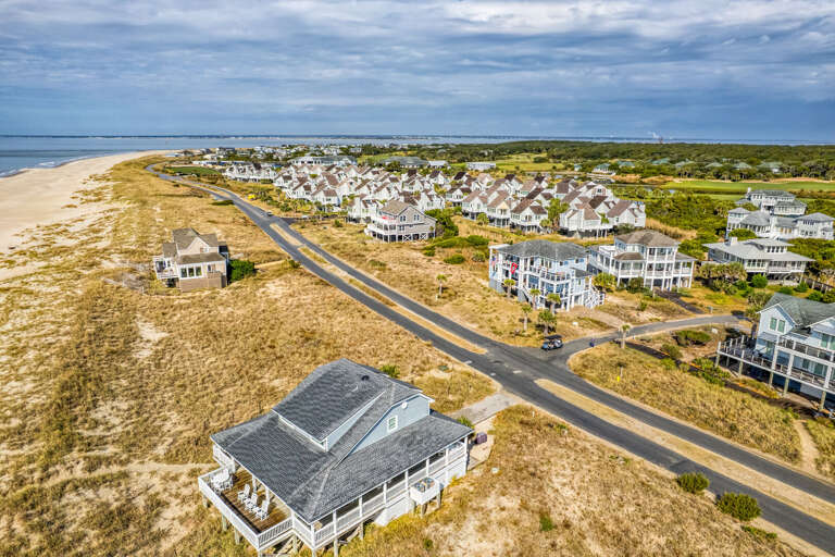 Aerial View Of Beachside Residences Beside Barren Dunes