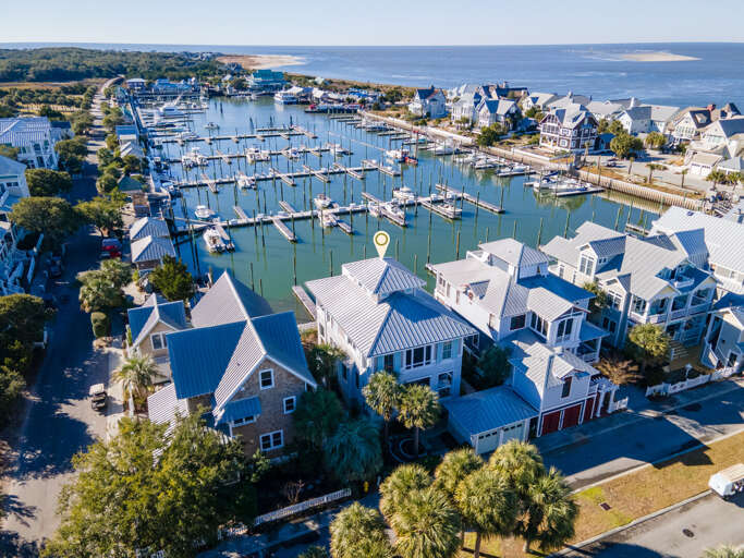 Aerial View Of Vibrant Village With Vast Marina And Verdant Trees