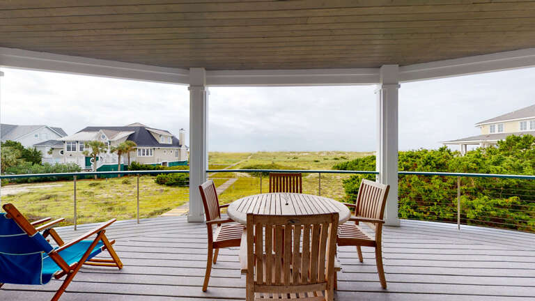 Porch With Wooden Table, Chairs, Overlooking Grassy Dunes