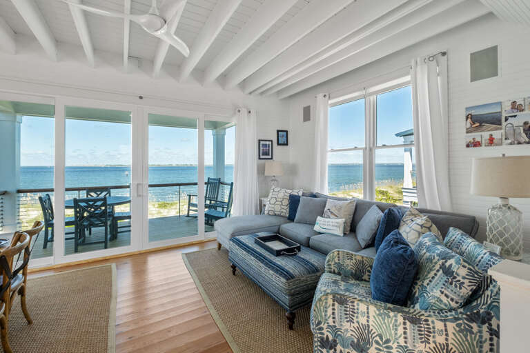 Bright Seaside Living Space With Expansive Ocean Views, Plush Seating, And Large Windows In Vacation Rental