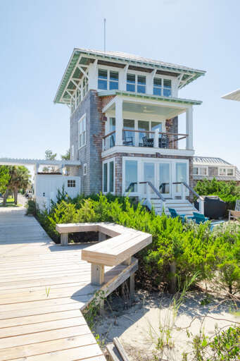 Beachside Building Beside Boardwalk Bordered By Bushes