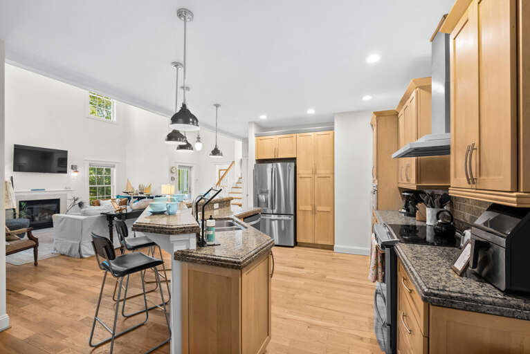 Bright Kitchen With Wooden Cabinets And Stainless Steel Appliances, Leading To An Adjoining Dining Area
