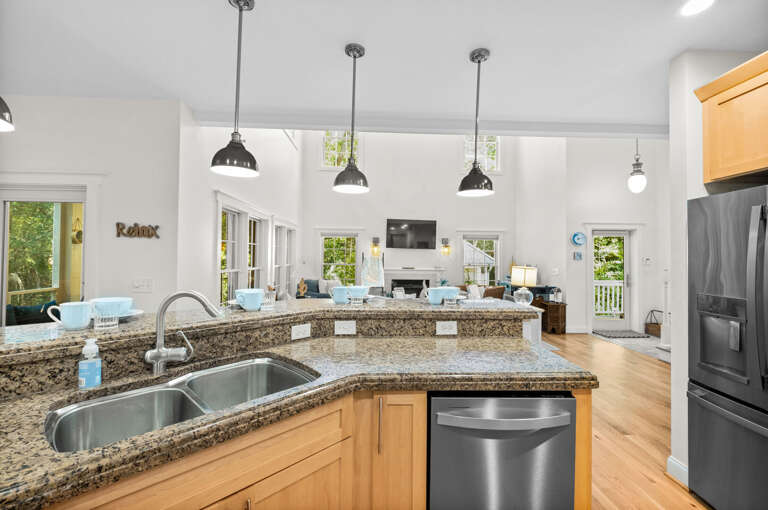 Bright Kitchen Boasting Stainless Steel, Spacious Counters, And Pendant Lighting