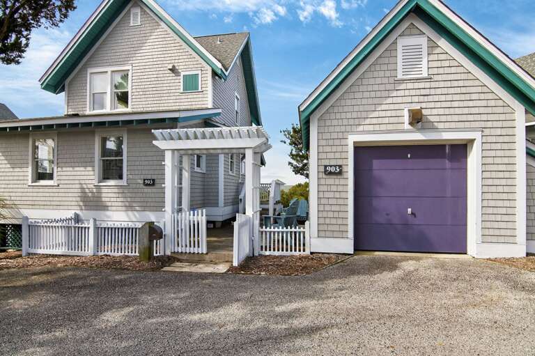 Wooden House With White Fence And Purple Garage Door