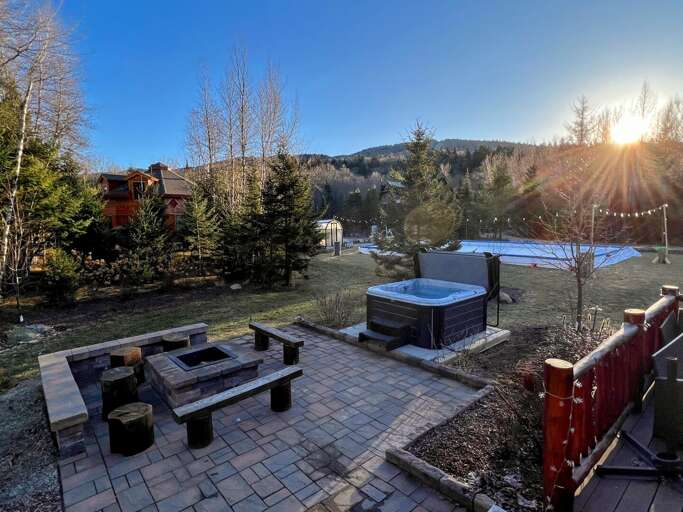 Patio with fire pit, hot tub and ice skating rink in the background