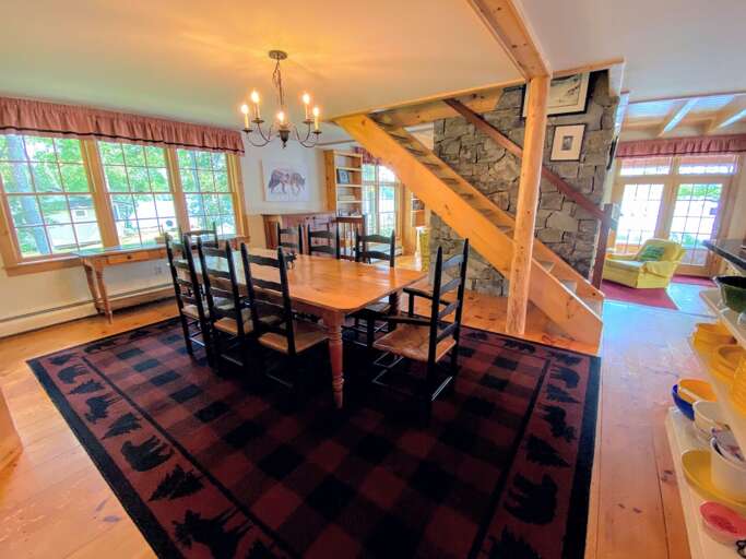 Open concept space extending from the living to dining area and the massive stone fireplace in between. Open concept space extending from the living to dining area and the massive stone fireplace in between.