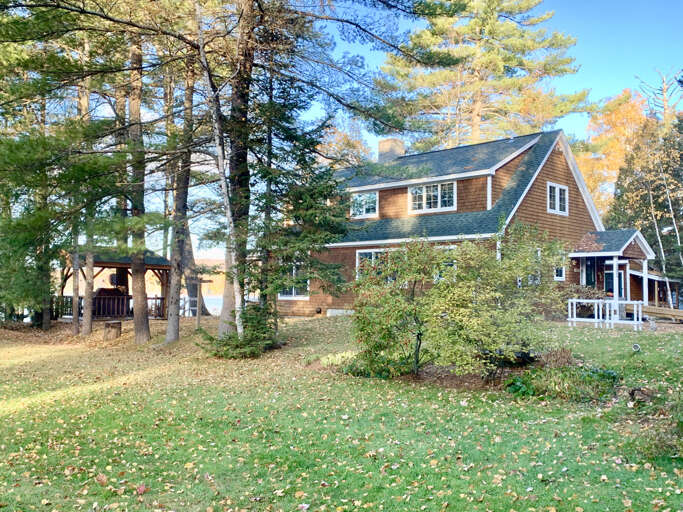 View of the lake house and gazebo during summer. View of the lake house and gazebo during summer.