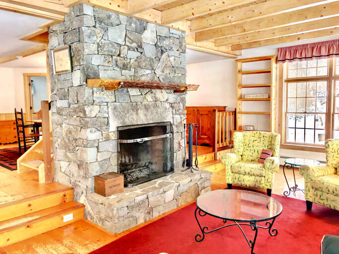 View of the living room featuring the grand stone fireplace. View of the living room featuring the grand stone fireplace.