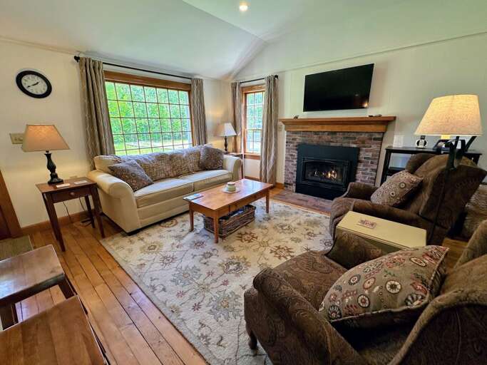 Living area with attached kitchen and dining areas includes fireplace and TV