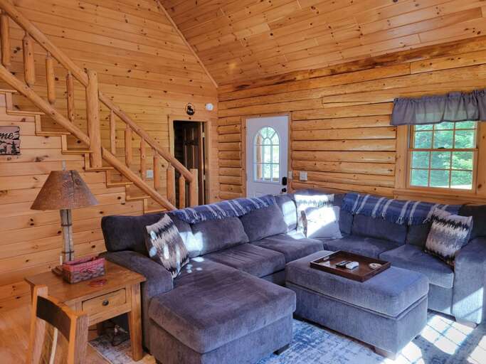 Wooden Cabin Interior With Sectional Sofa And Stairs