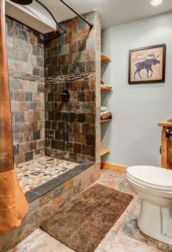 Bathroom #4 is full bath located on the lower level with a river stone shower.