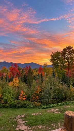 A colorful morning sky lights up the mountain ridgeline above the autumn foliage.